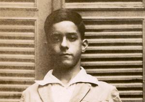 Dressed in his school uniform, at about ten years old.